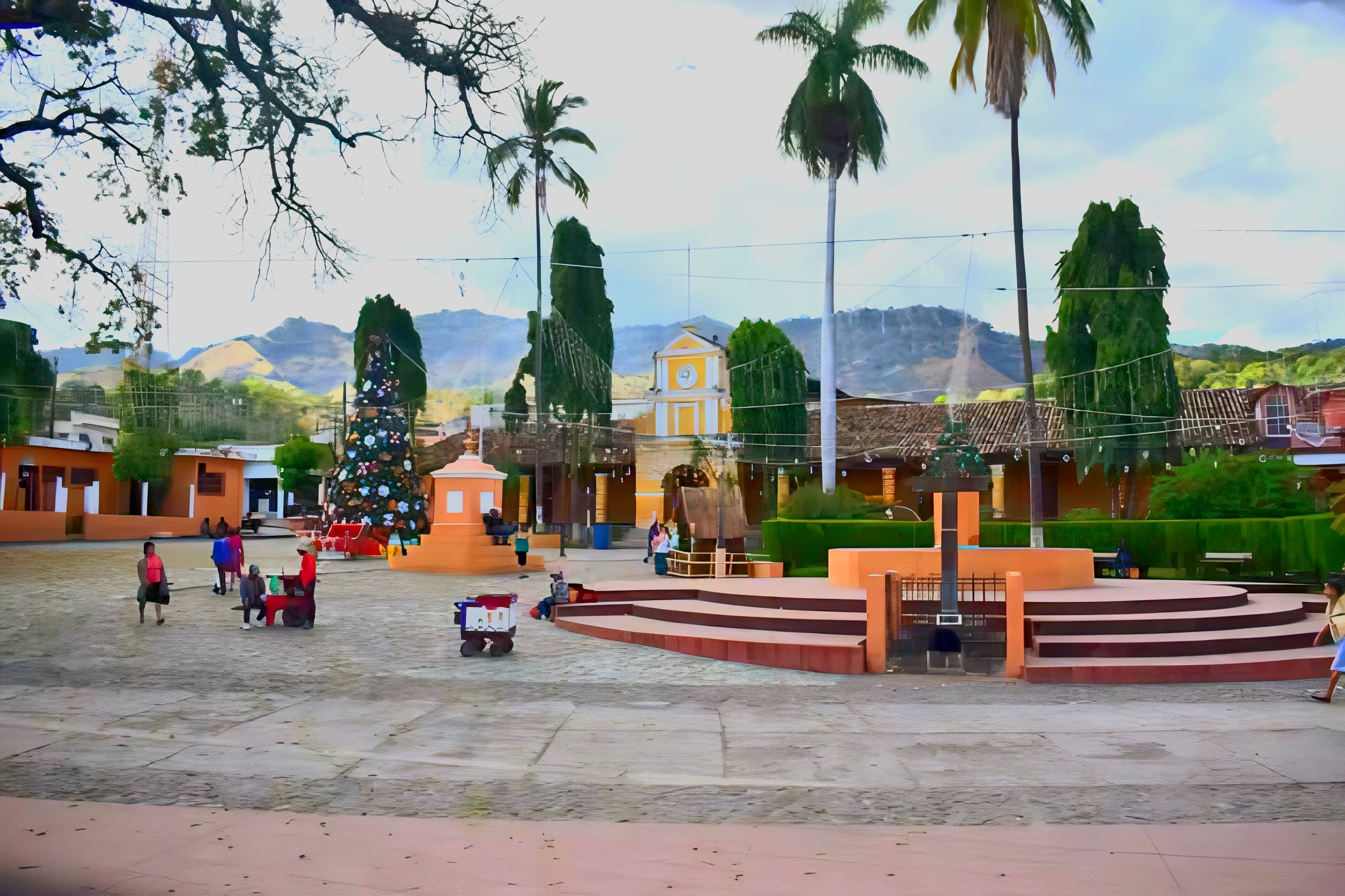 Plaza central de San Luis Jilotepeque con palmeras y montañas al fondo